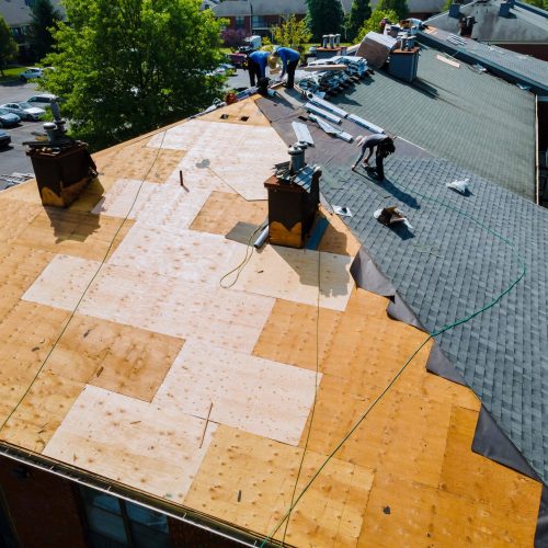 Roof repairs old roof replacement with new shingles of an apartment building